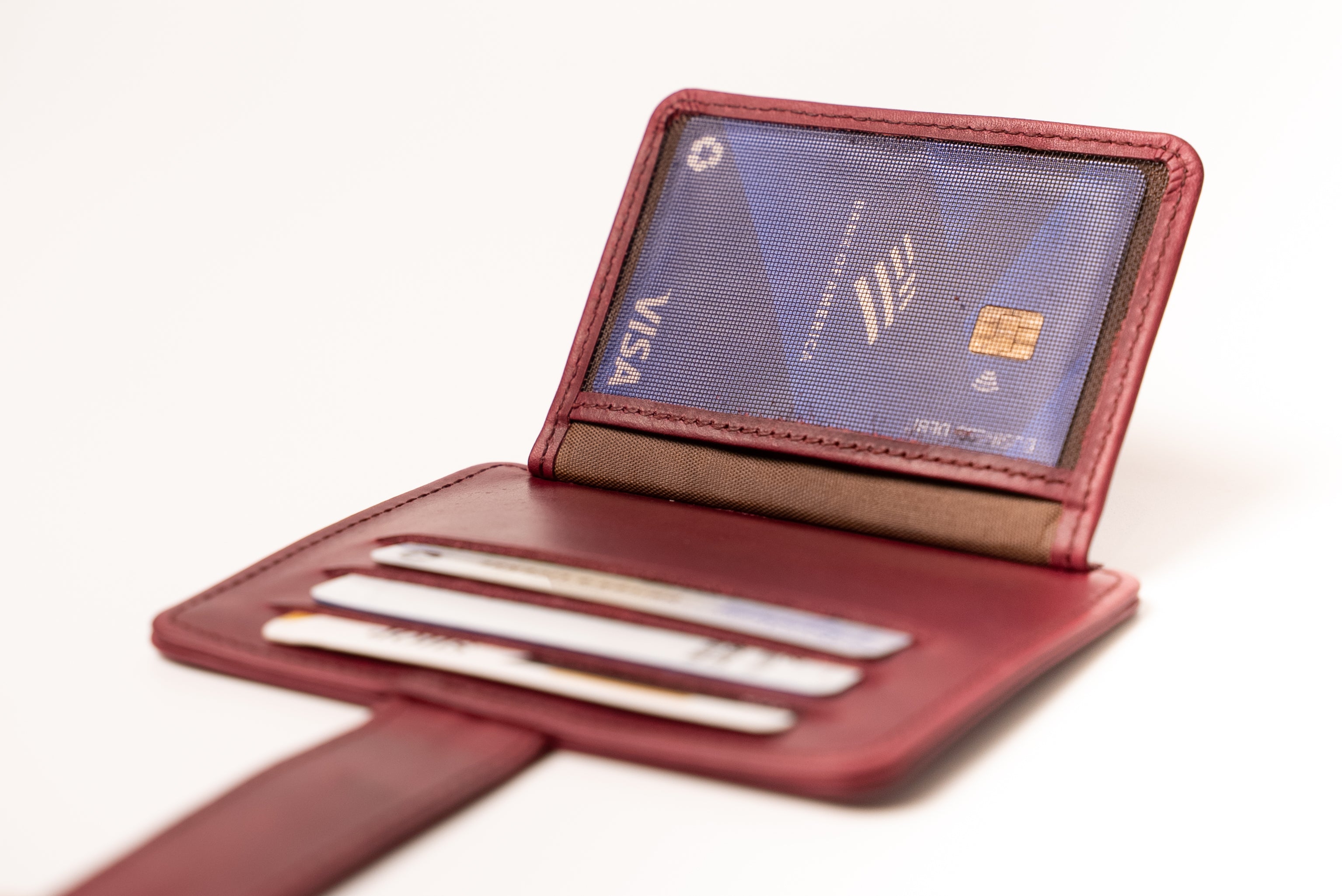 Red leather wallet with a Visa card on a white background