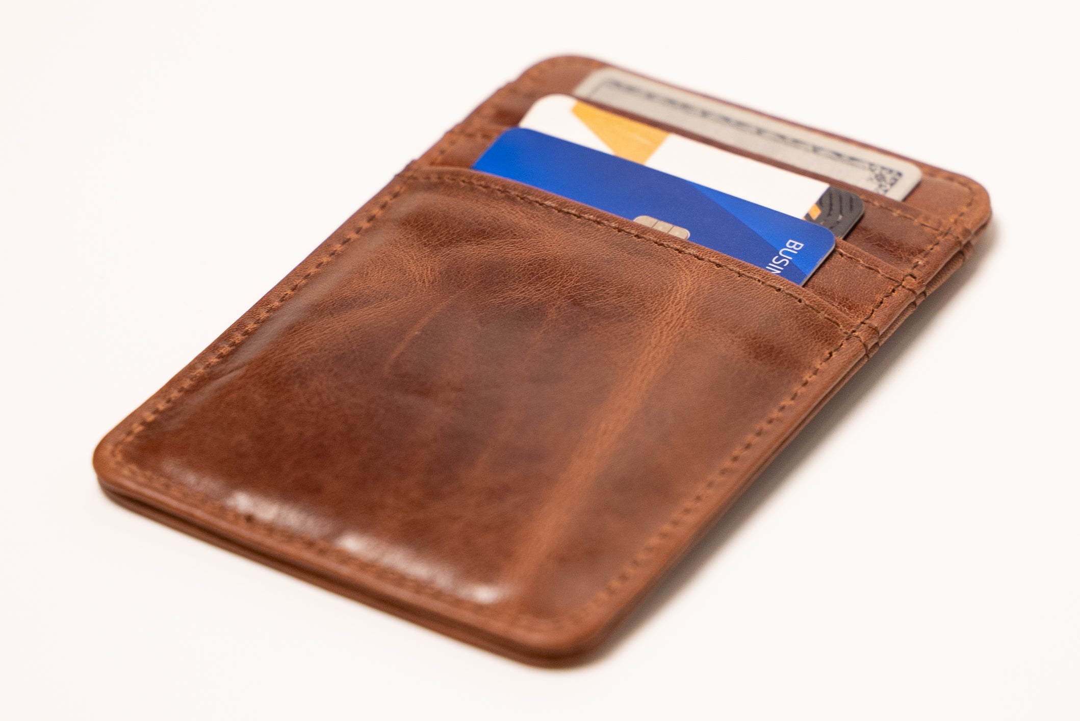 Brown leather cardholder with cards on a white background