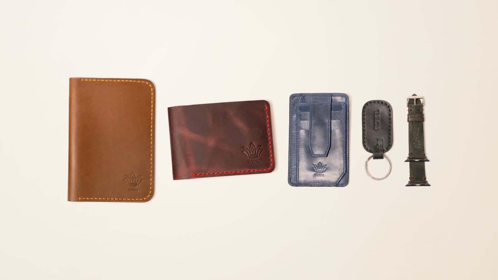 ROYAL leather gifts in a row: tan passport cover, burgundy bifold, navy card holder, black keychain, olive watch band