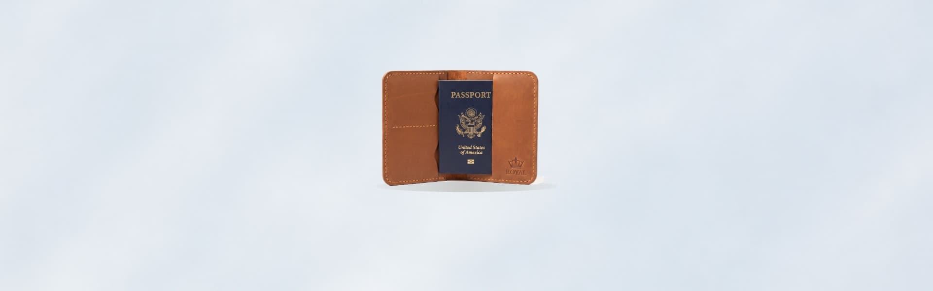ROYAL leather passport cover on a pale chalk backdrop