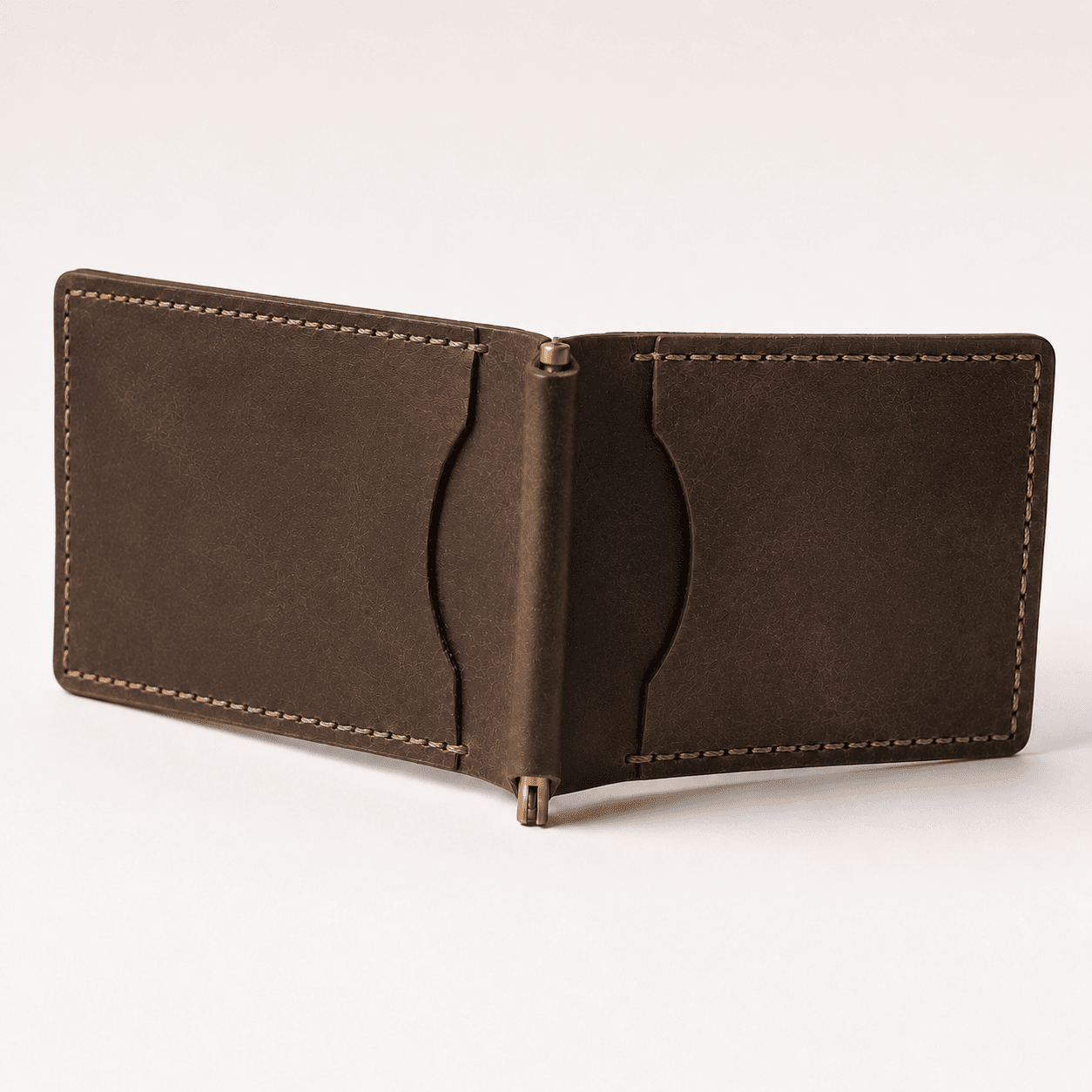 Brown money clip wallet opened flat, brass spring clip and card slots, angled view