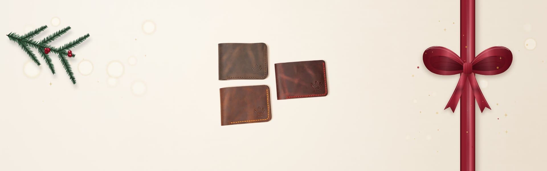 Three ROYAL full-grain leather bifold wallets in olive brown, burgundy and brown on warm stone in soft daylight