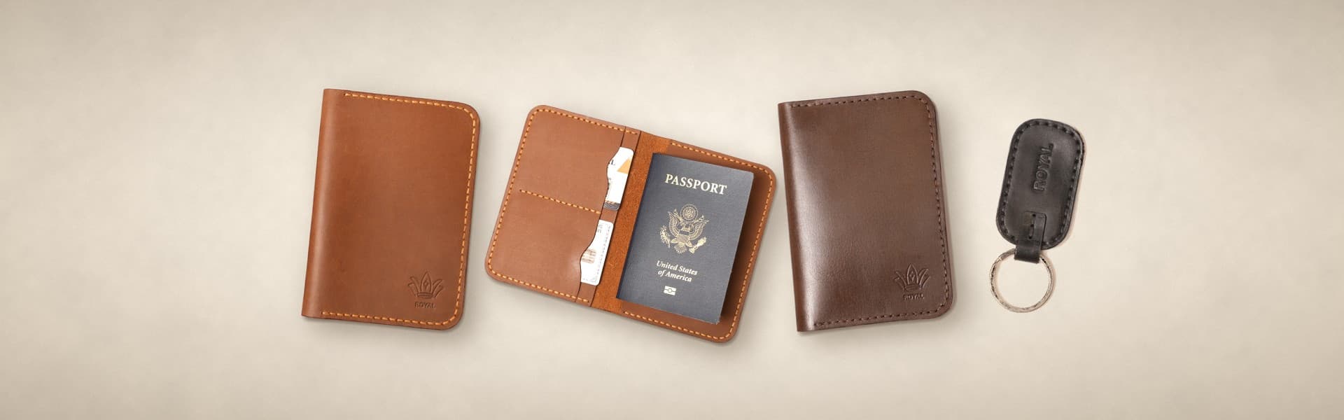 ROYAL leather passport covers in tan and dark brown, an open cover holding a passport and a black keychain on a warm cream surface