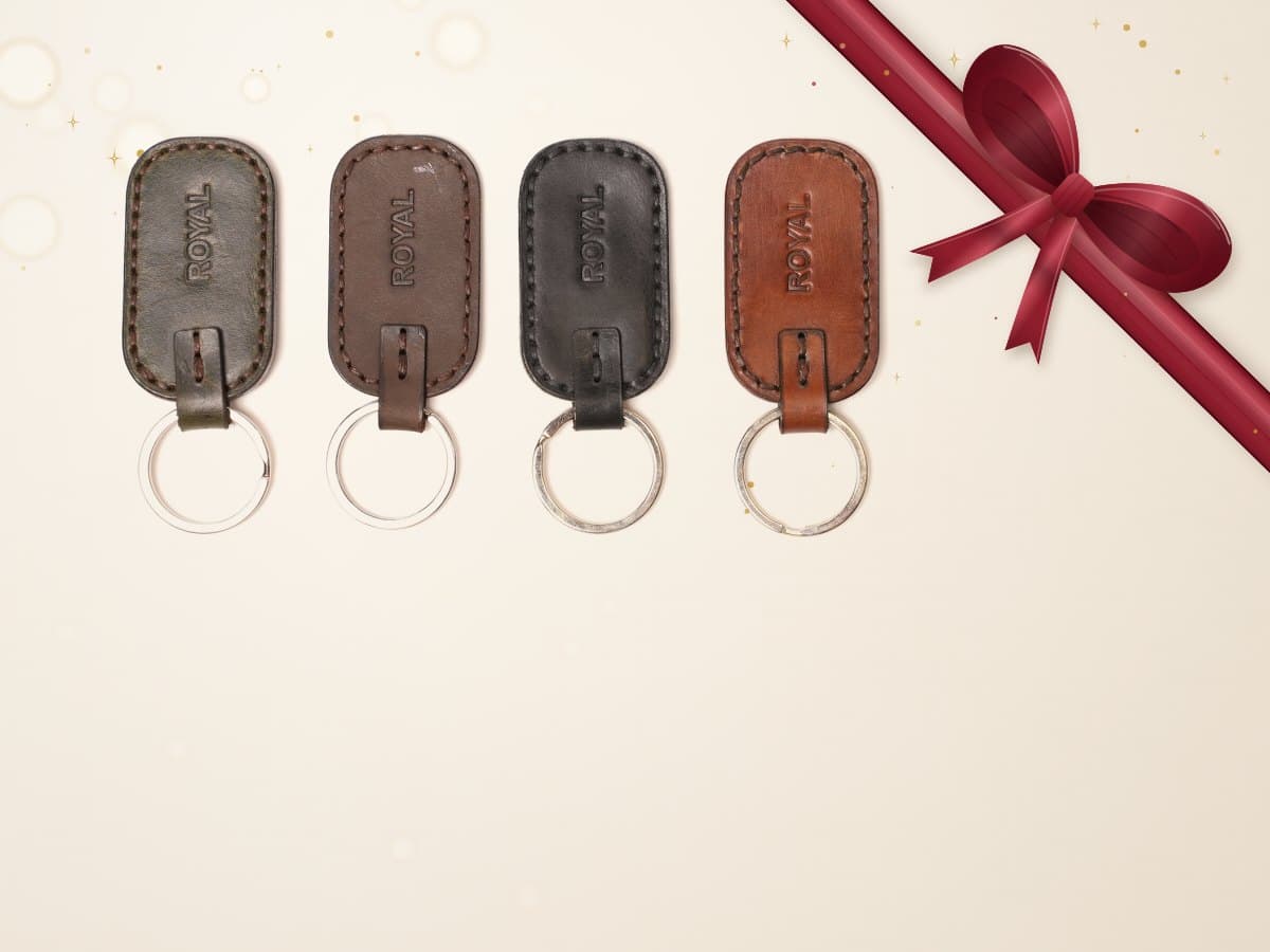 ROYAL leather keychain on a light stone backdrop