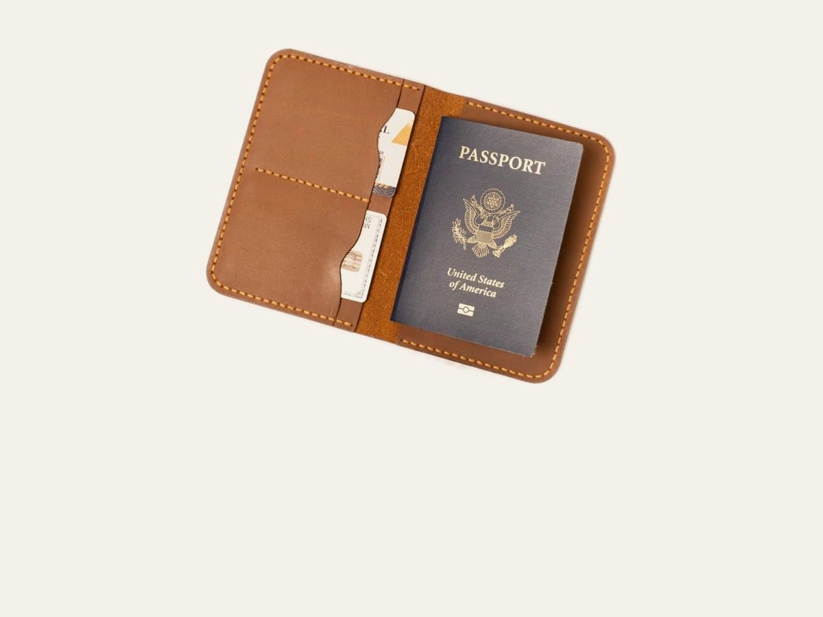 ROYAL leather passport cover in camel, open with a passport