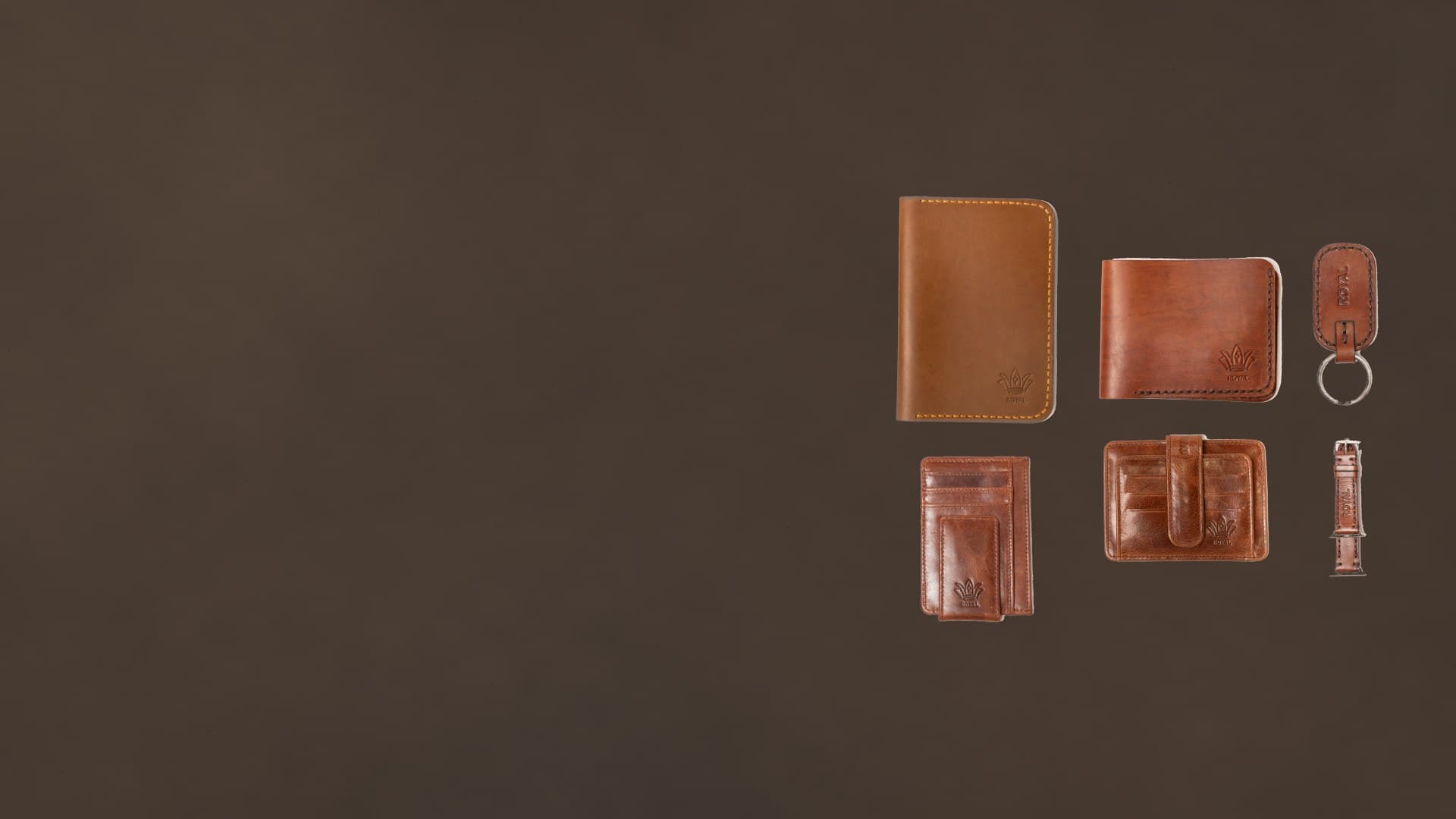 Tan and cognac ROYAL full-grain leather pieces on dark walnut stone: passport cover, wallets, card holder, keychain and watch band