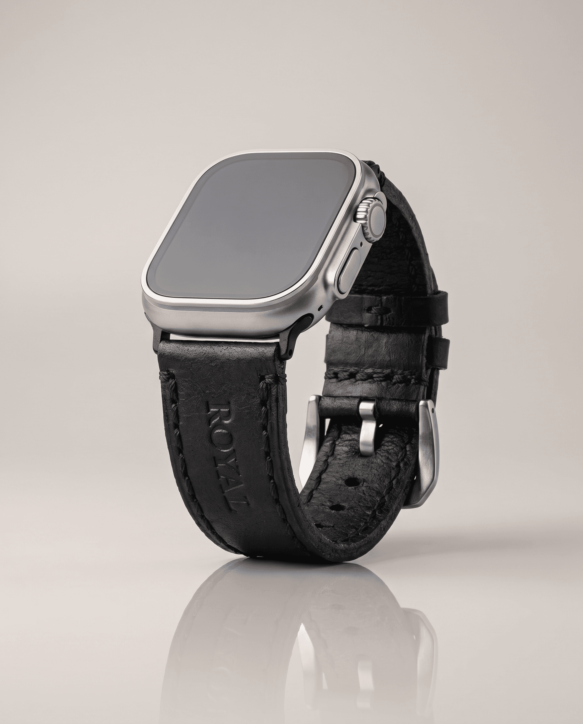 Black leather Apple Watch band angled to show the stitching, steel connectors and buckle