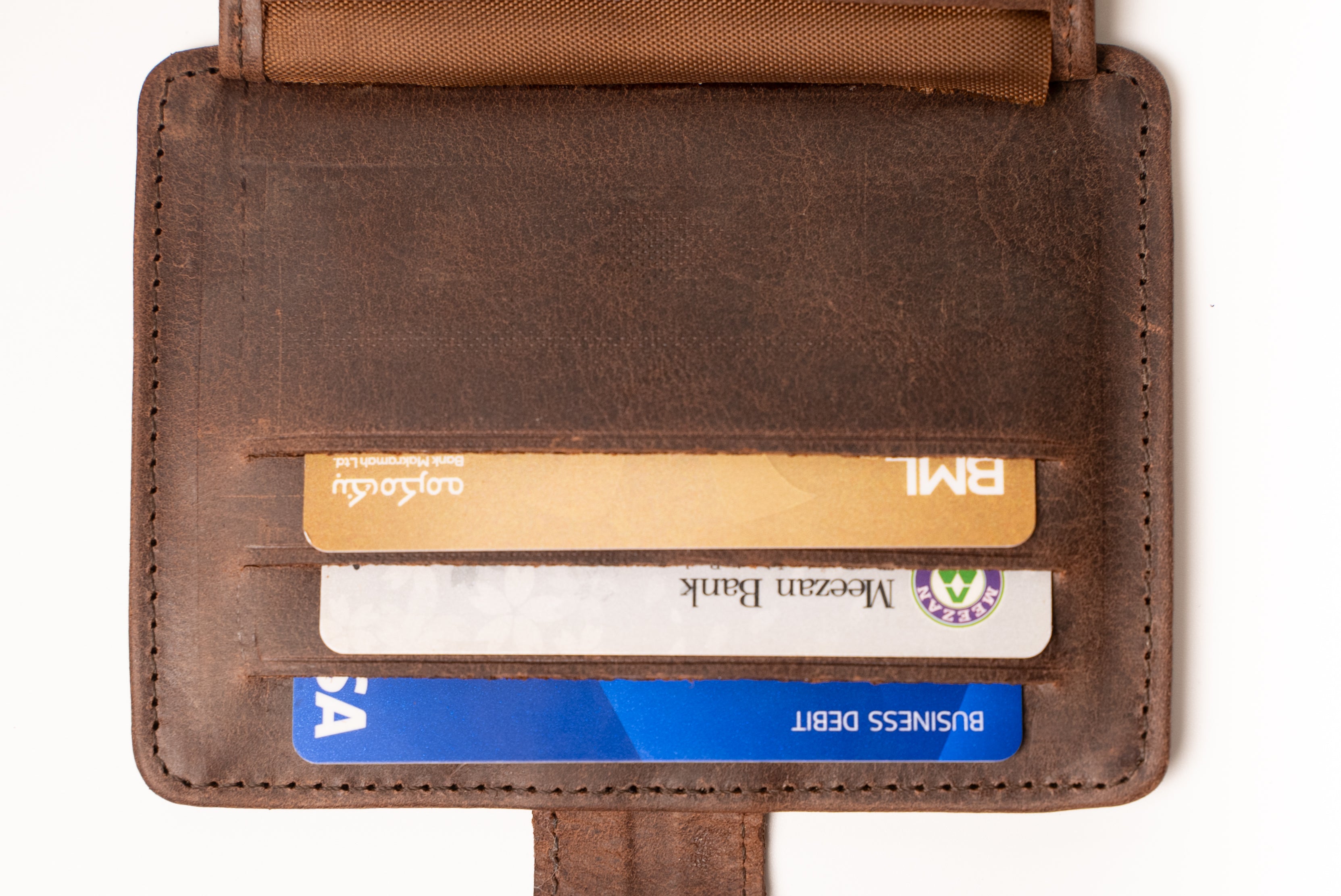 Brown leather wallet with cards inside on a white background
