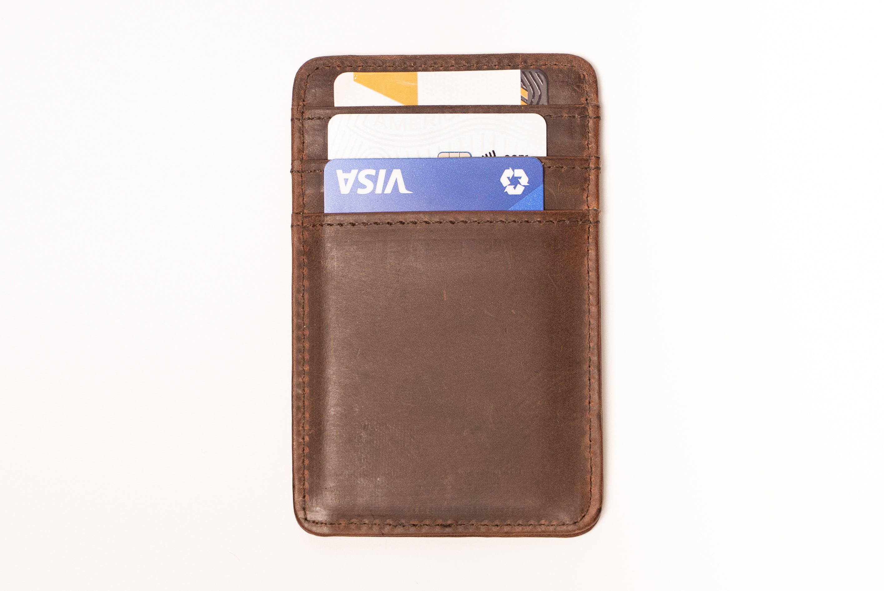 Brown leather cardholder with a Visa card on a white background