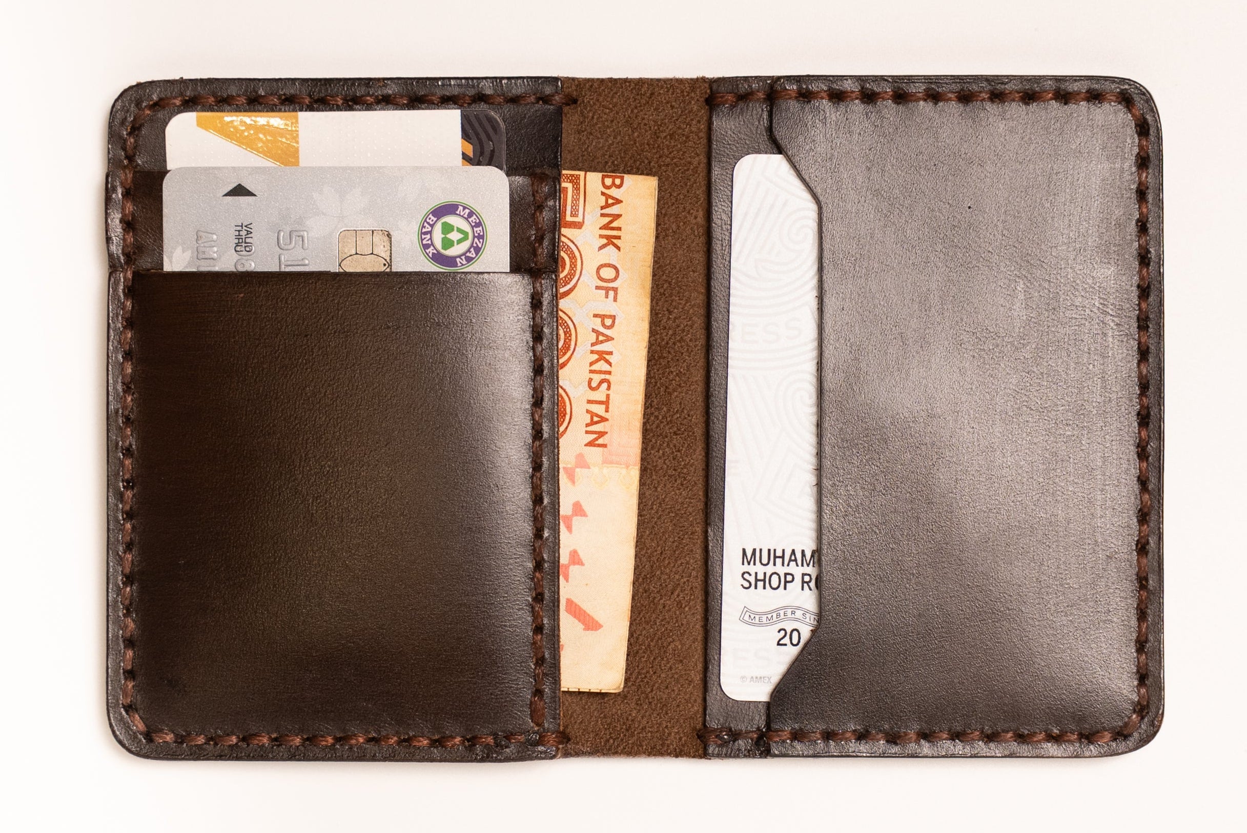 Brown leather wallet with cards and money on a white background